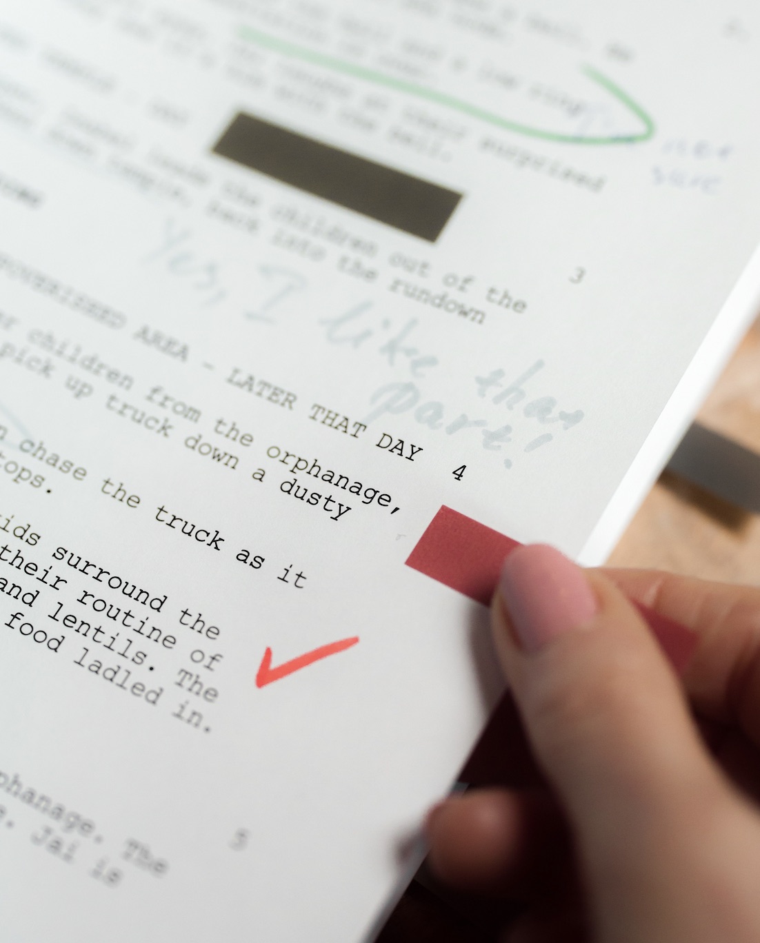 A page of screenplay marked up in red and green pen.